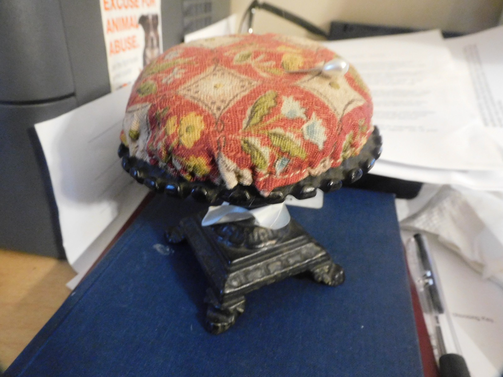 vtg. cast iron footed sewing pin cushion with  printed cover