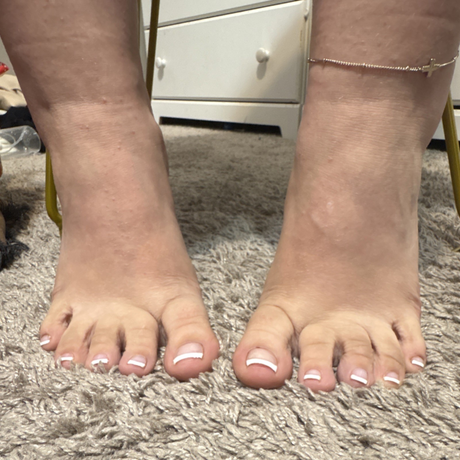 Close-Up Photograph of Feet with French Pedicure and Anklet on Carpet