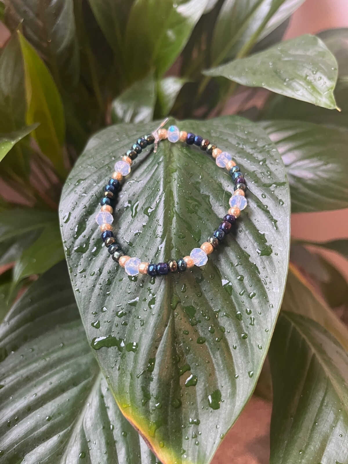 This blue, gold, and clear beaded bracelet is handmade by Gracie.