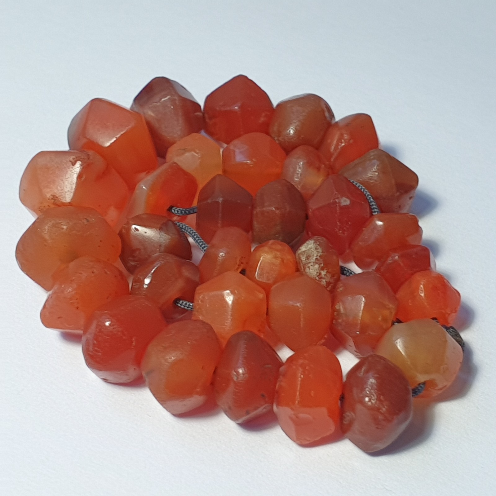 A RARE STRAND OF 33 ANCIENT CARNELIAN FACETED AGATE BEADS (9mm to 15mm)