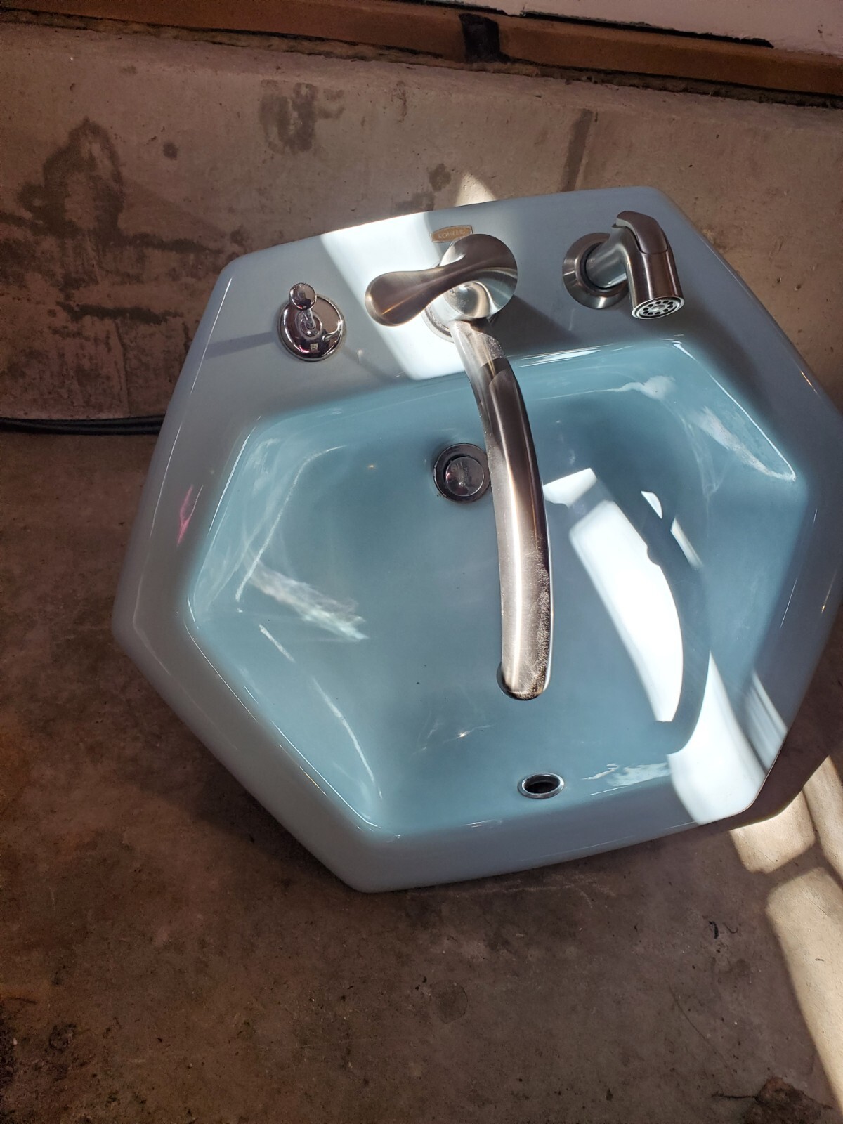 @ Koler porcelain sinks with counters, one blue, one gray, with faucets and pipe