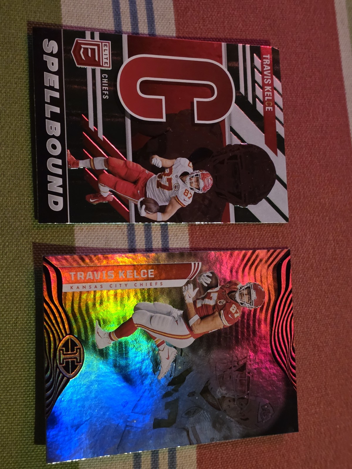 Travis Kelce 2 card lot: 2022 Panini Red Holo & 2023 Panini Spellbound Elite